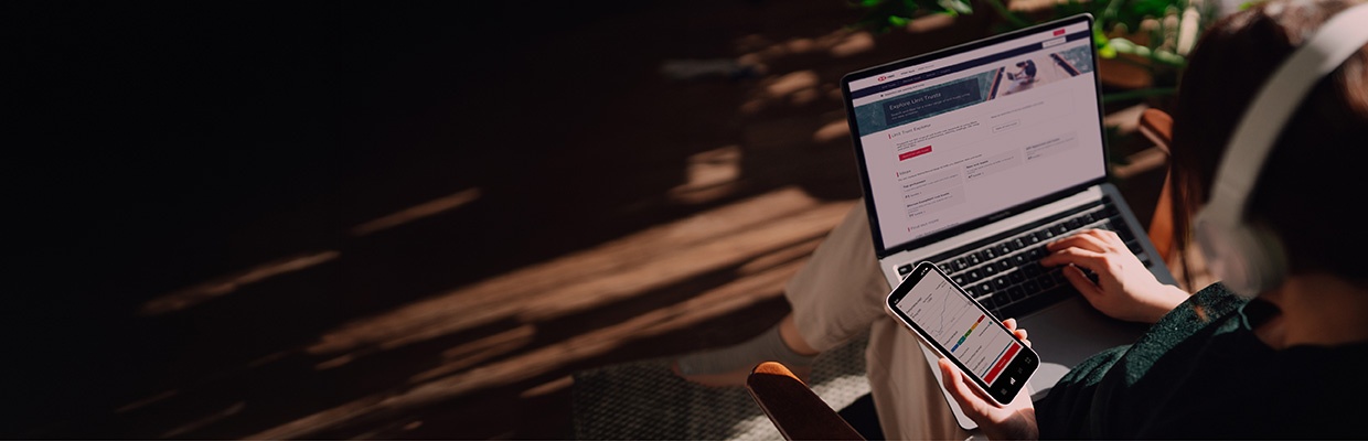 A man is holding a mobile phone and a tumbler in a dining place; image used for HSBC Amanah EZInvest page
