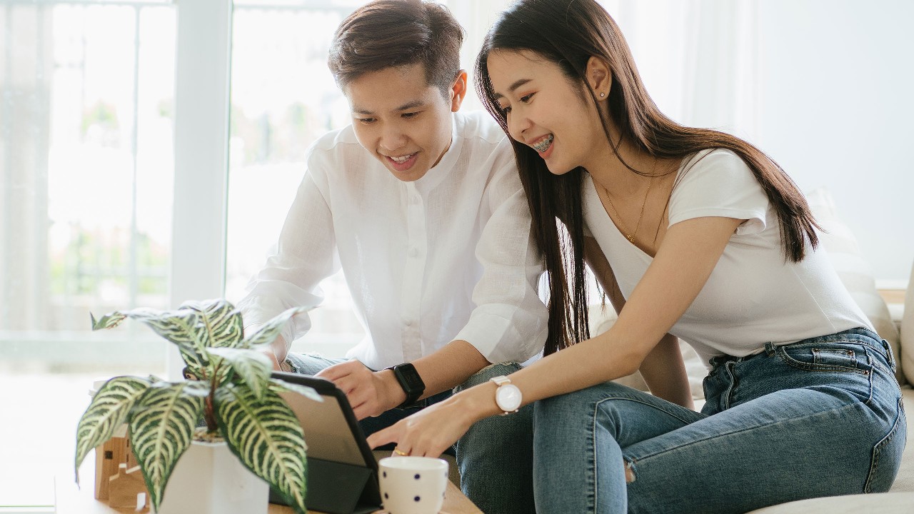 A couple is using tablet at home; image used for HSBC Malaysia digital account opening page.