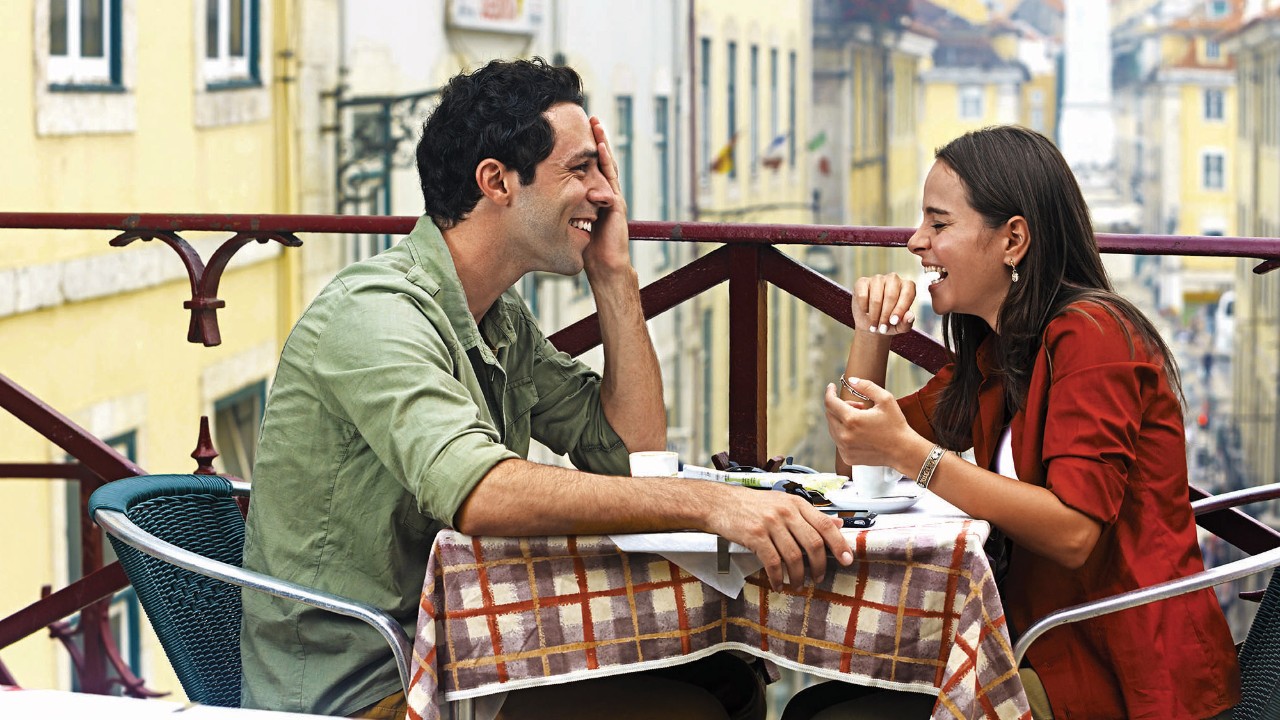 A couple is laughing at a outdoor cafe; image used for HSBC Individual expertise and support page.