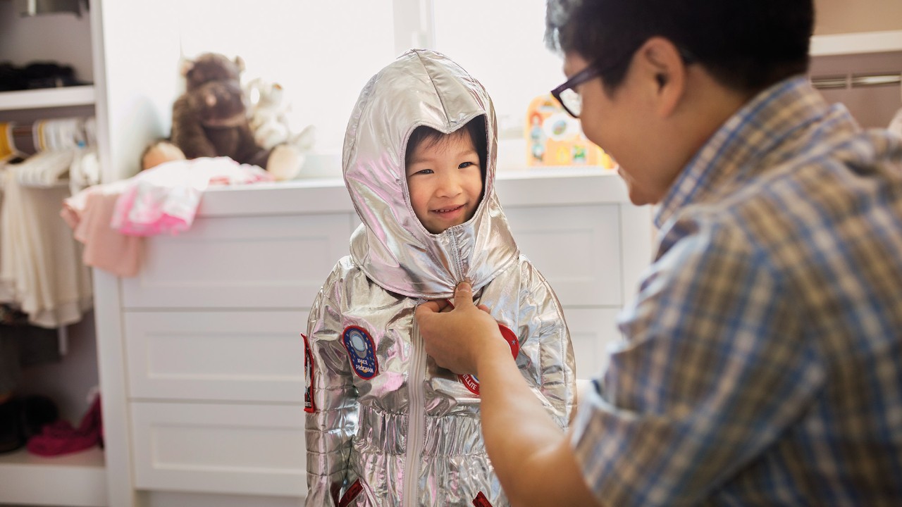 A father helps child to dress; image used for HSBC Malaysia Amanah Advance
