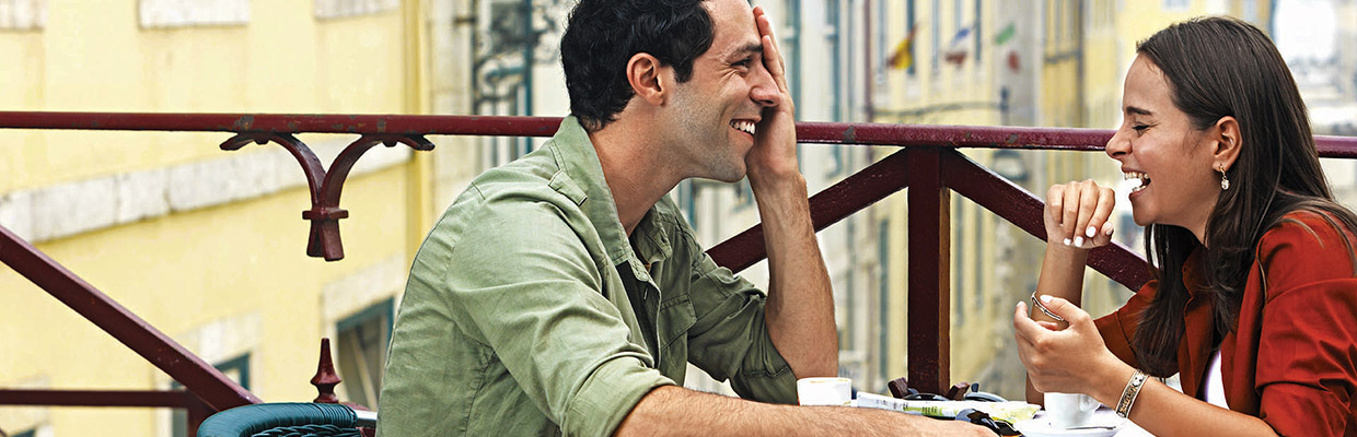 A couple is laughing at a outdoor cafe; image used for HSBC Individual expertise and support page.
