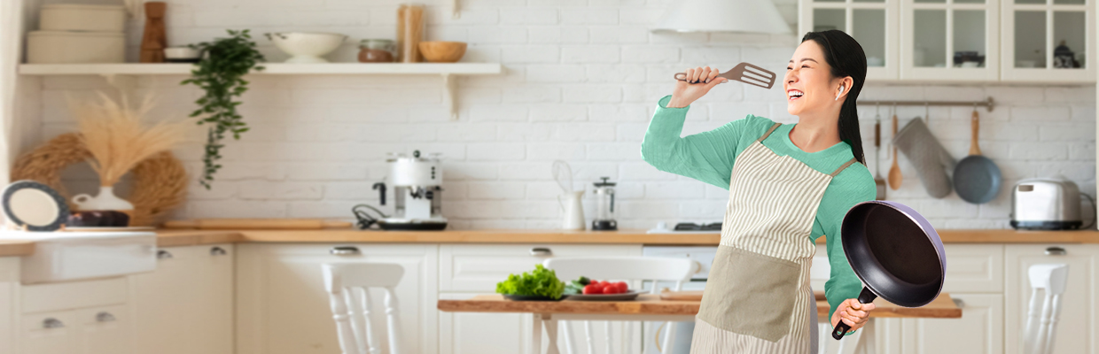 A woman is standing in the kitchen; image used for HSBC Amanah cash back promotion page.