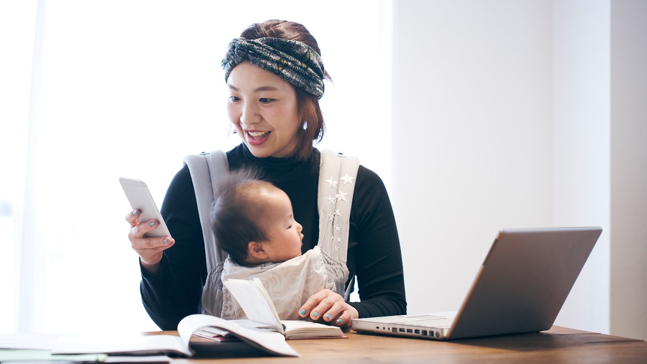 Mother with baby working at home; image used for HSBC Malaysia Amanah Remote Engagement Service page