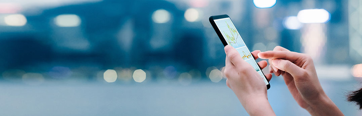 Woman using phone outside; image used for HSBC Malaysia Investments page.